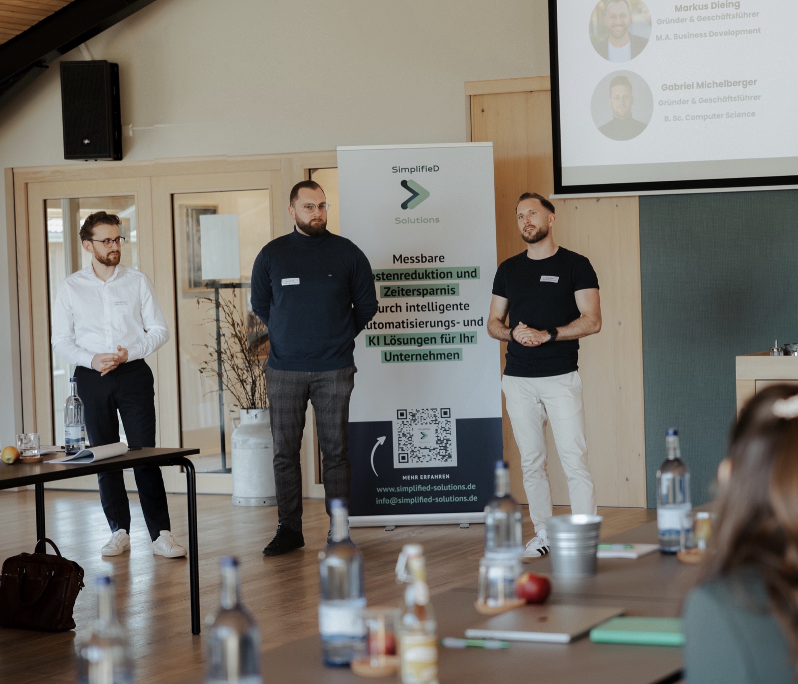 Three SimplifieD Solutions founders in front of the rollup banner